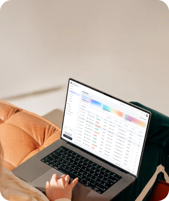Person using laptop showing a data audit or analytics dashboard with tables and colorful metrics.