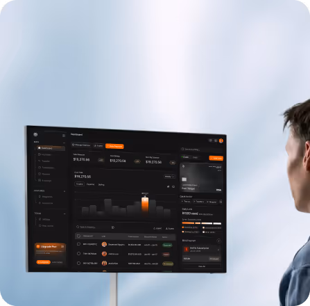 Person looking at a large digital dashboard screen showing financial data, charts, and transaction details.